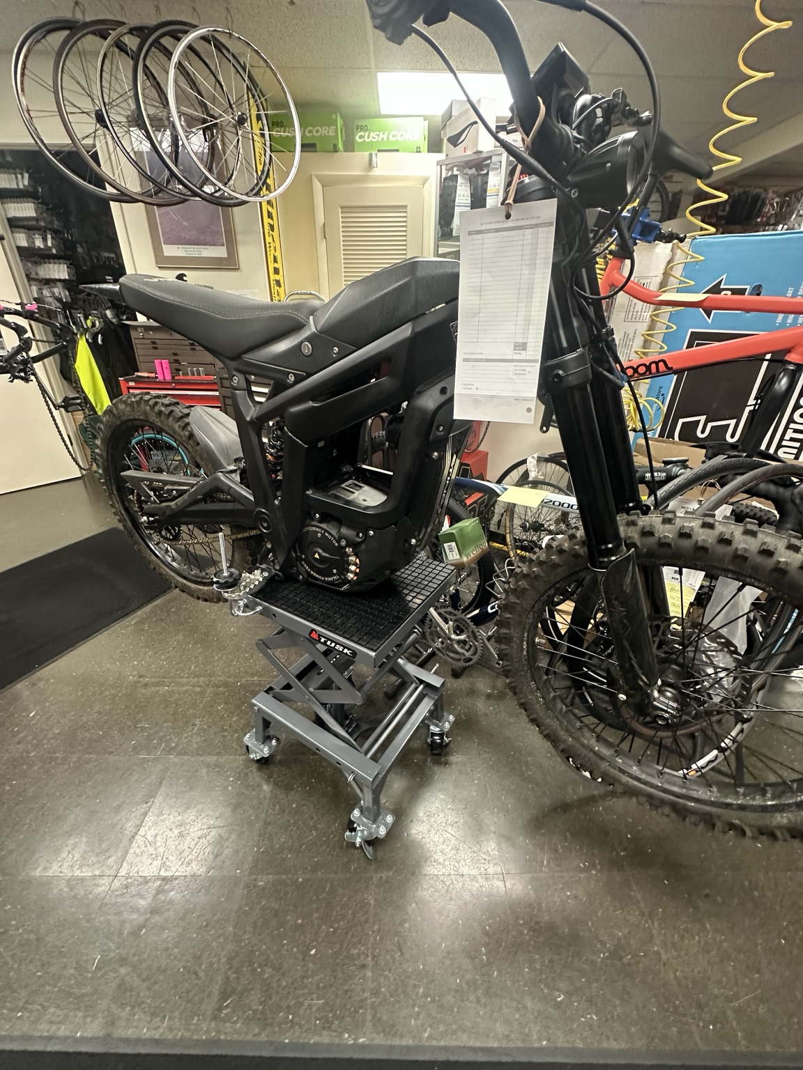 Talaria-style e-moto bike on shop service equipment at Bicycles Plus