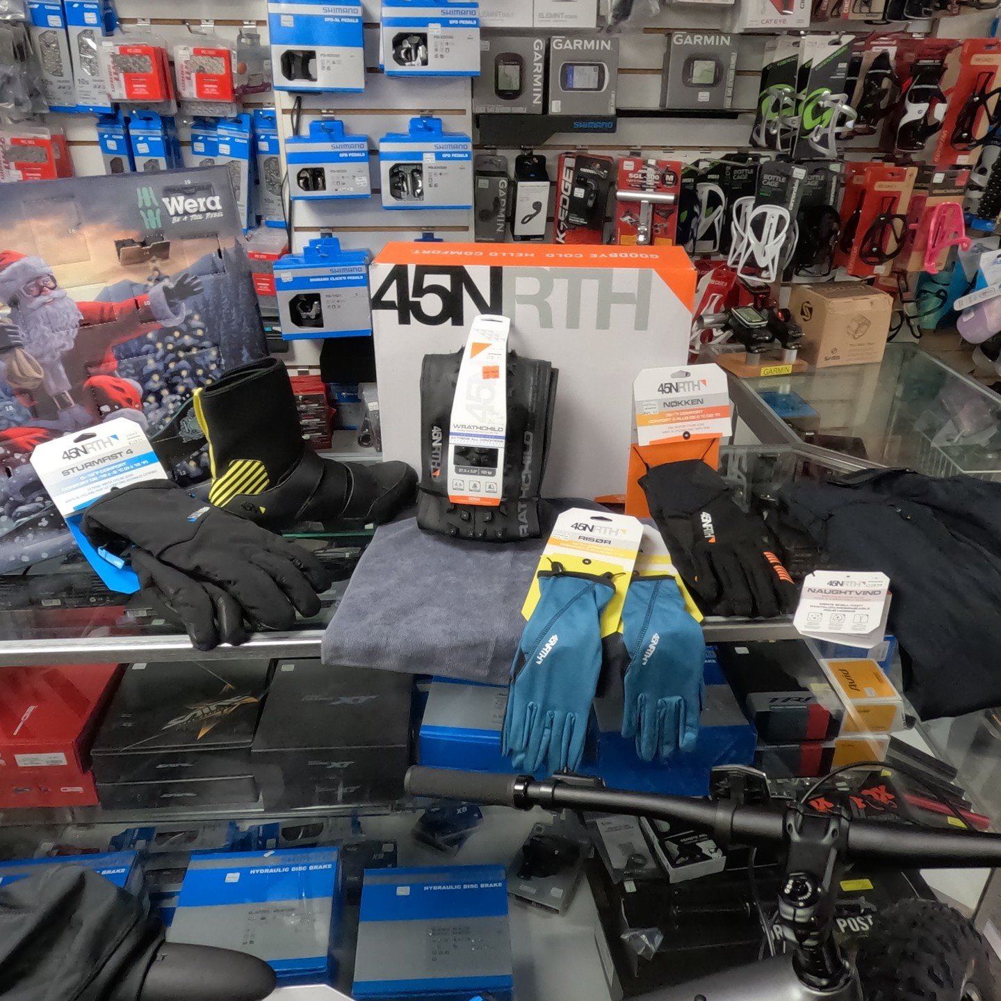 Cold-weather gloves, footwear, tires, computers, and cycling accessories displayed in the shop