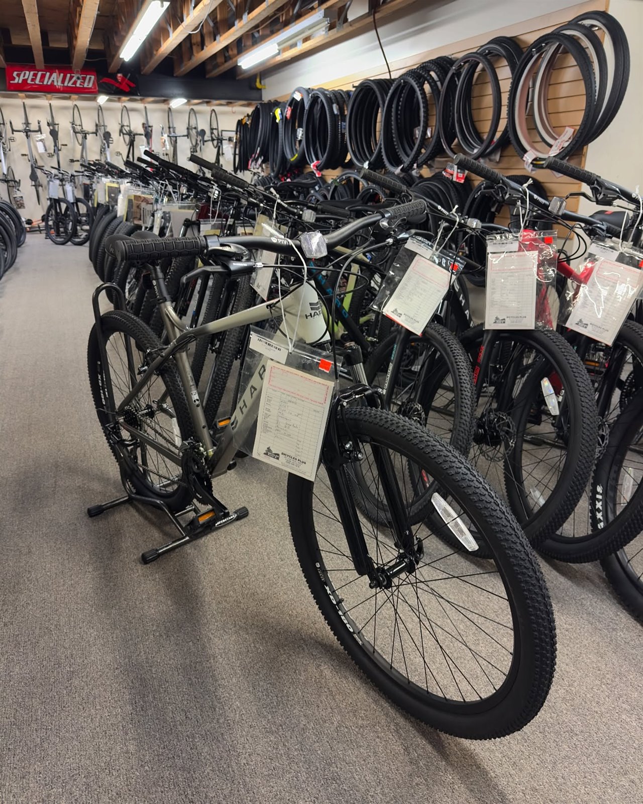 Rows of bikes beside the replacement tire wall at Bicycles Plus